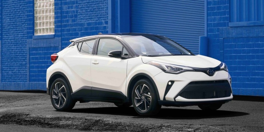 A white 2022 Toyota C-HR subcompact SUV is parked on the sidewalk. 