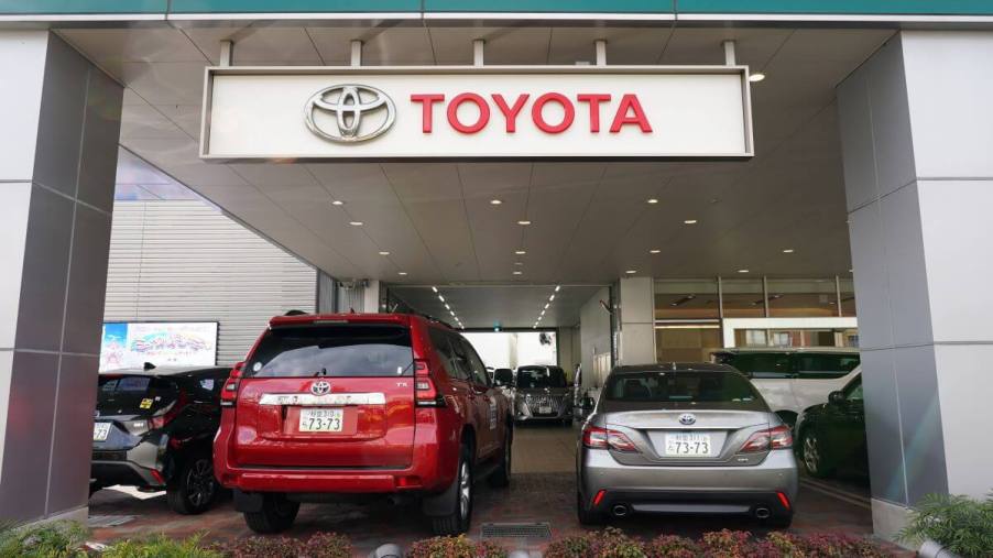 A Toyota Land Cruiser SUV and Crown sedan on display at a dealership in Tokyo, Japan