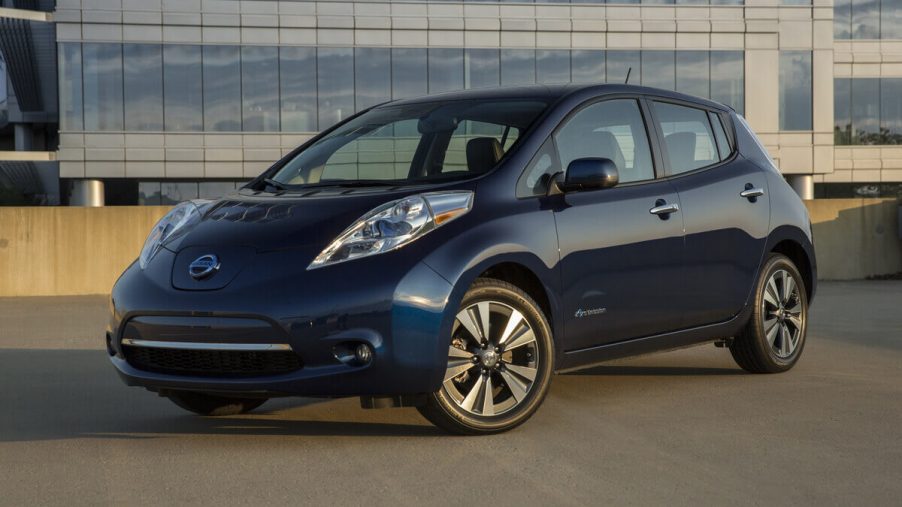 A used blue 2015 Nissan LEAF shows off its front-end styling on a parking garage roof.