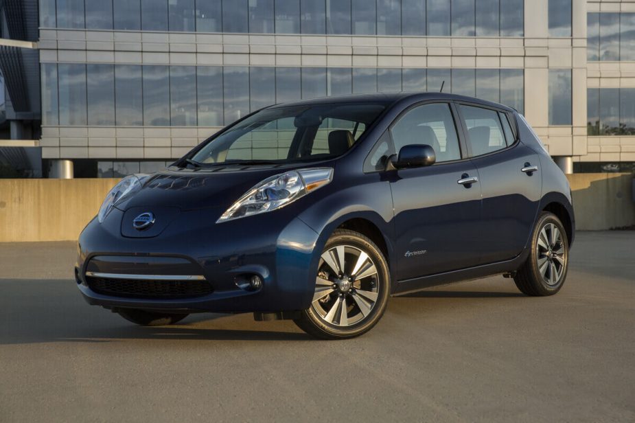 A used blue 2015 Nissan LEAF shows off its front-end styling on a parking garage roof.