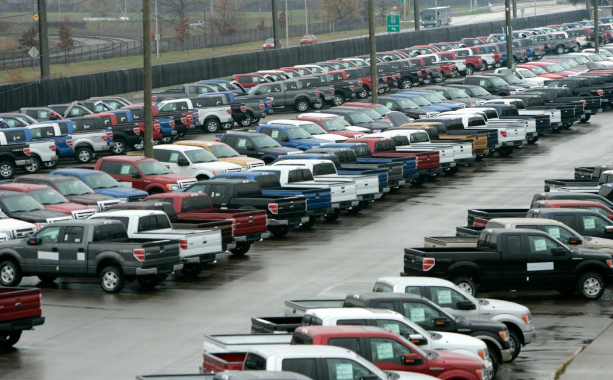 Rows of pickup trucks parked outside a facility.