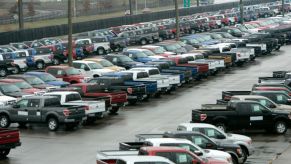 Rows of pickup trucks parked outside a facility.