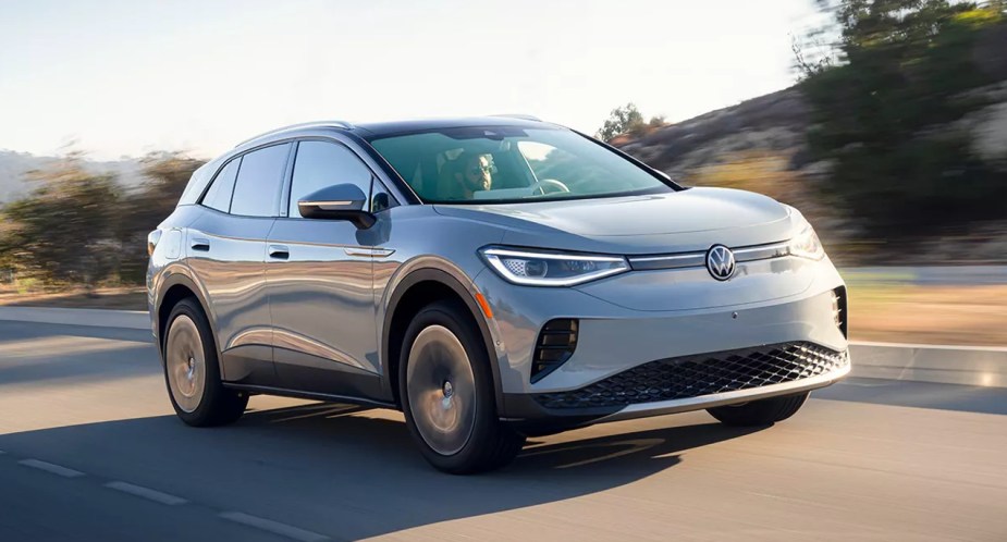 A gray 2023 Volkswagen ID.4 small electric SUV is driving on the road. 