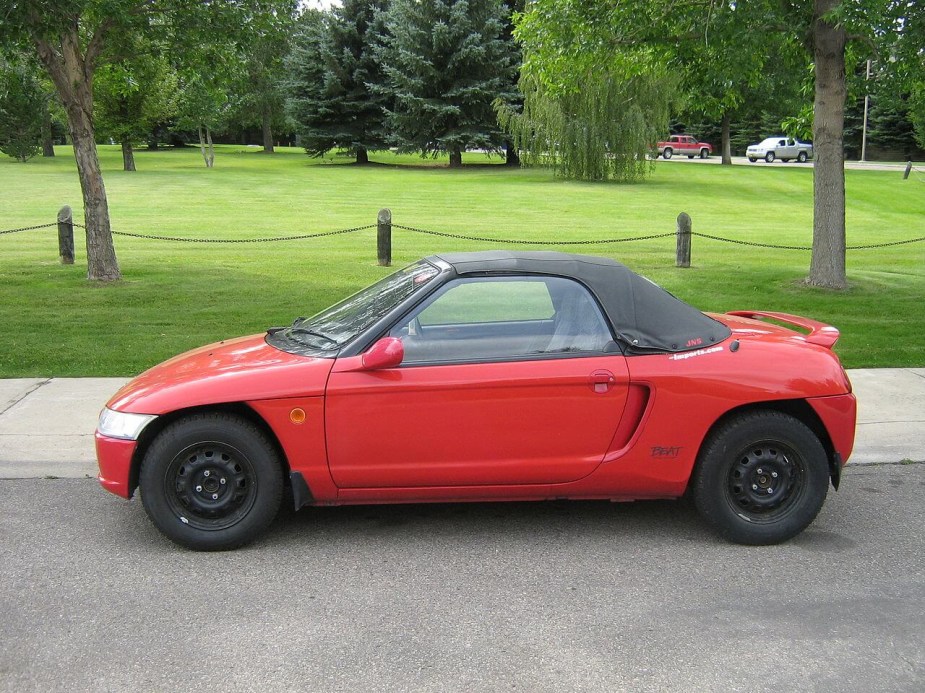 a red Honda Beat parked on the street