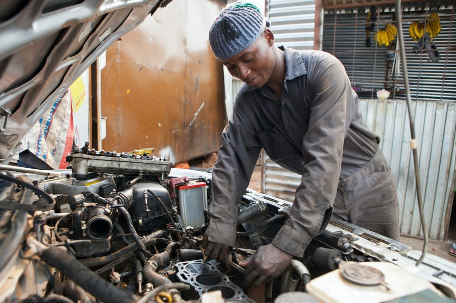 A mechanic working on an old engine.