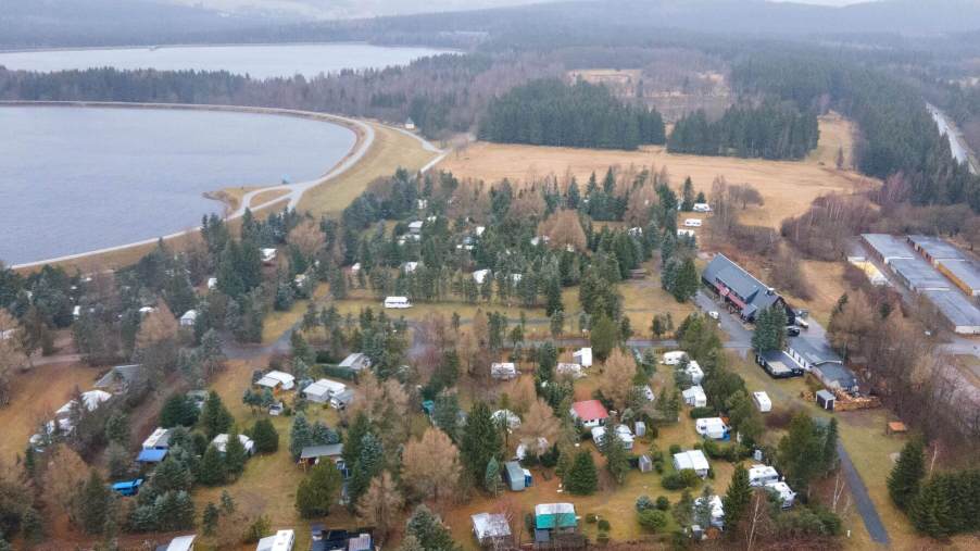 An aerial drone shot of motorhomes, RVs, and campers at the Galgenteich campsite in Altenberg, Saxony, Germany
