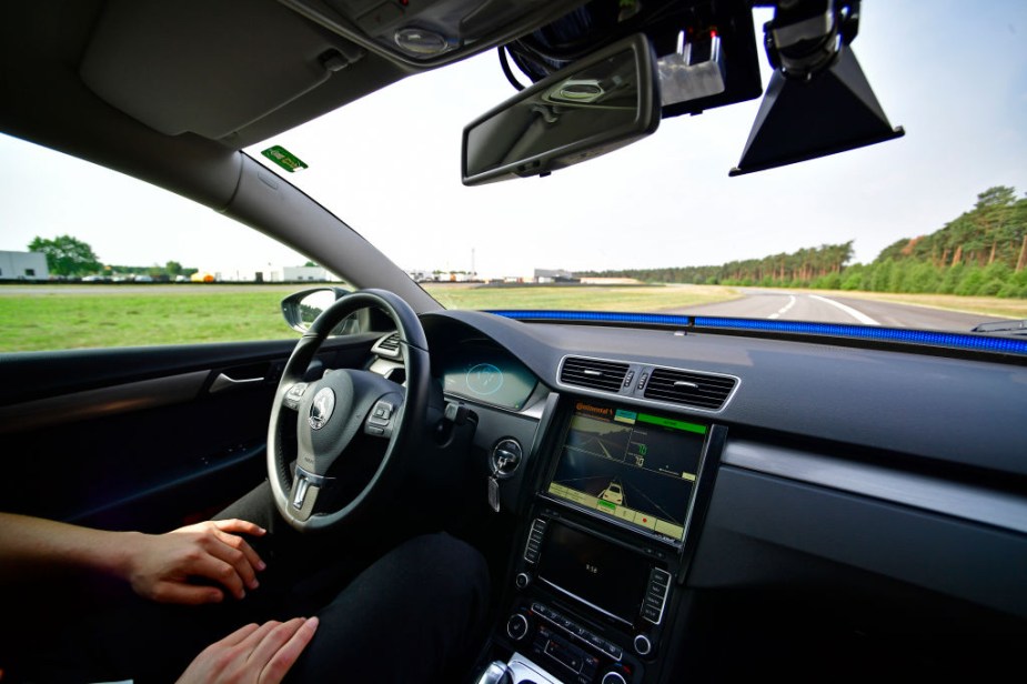 A driver presents a Cruising Chauffeur, a hands-free self-driving system.