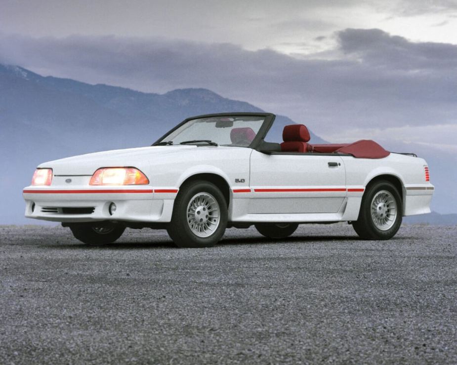 A white Fox Body shows off its convertible top.
