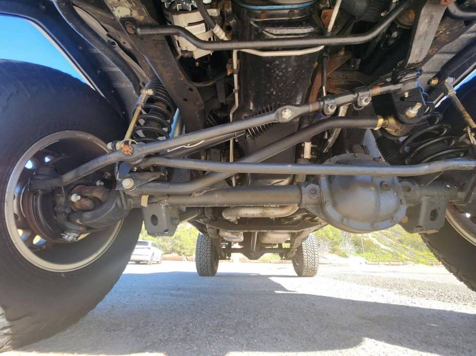 The suspension and underbody of a lifted 4WD Jeep Comanche pickup truck modified for off-roading.