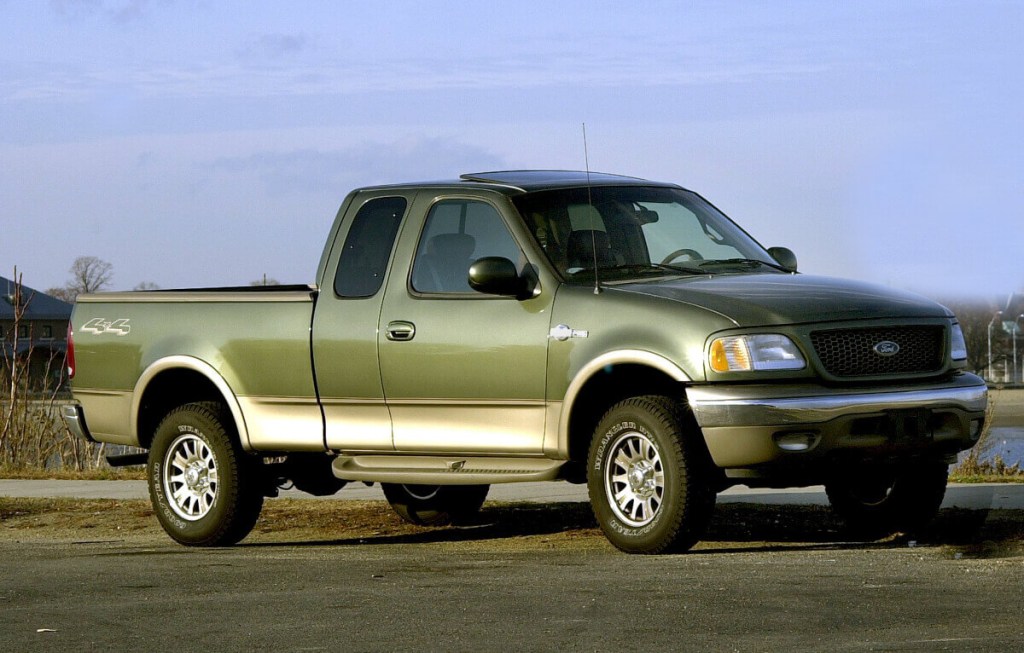 A Ford F-150 featuring the Triton V8 engine is parked on the street.