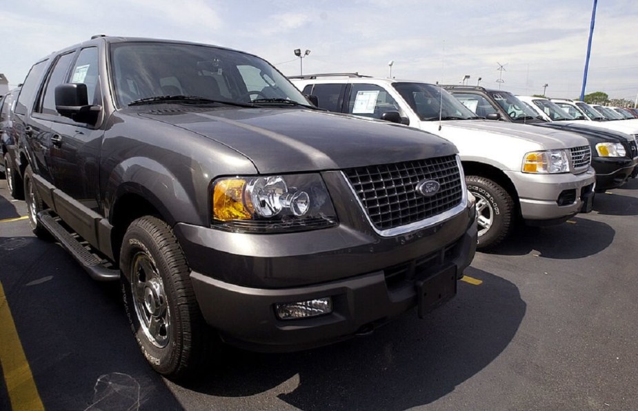 A series of Ford models, including several 2004 Ford Explorer SUVs line a lot. 