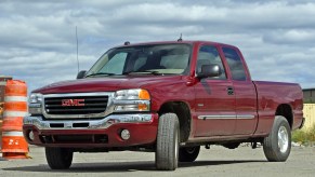 A red GMC Sierra pickup truck parked at a construction site.