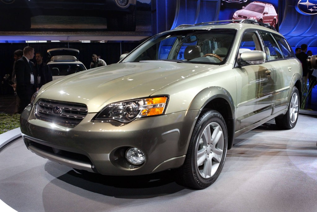 A gold 2005 Subaru Outback on display at an auto show. 