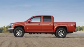 A four-door Chevy Colorado 1st-gen midsize pickup truck from 2009, parked on dirt for an advertising photo.
