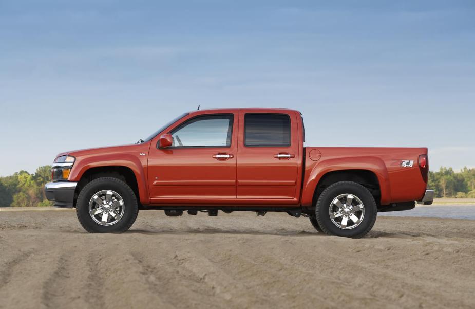 A four-door Chevy Colorado 1st-gen midsize pickup truck from 2009, parked on dirt for an advertising photo.