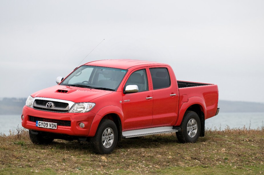 A 2009 Toyota Hilux midsize truck sits in front of some water.