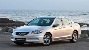 A used silver 2011 Honda Accord SE parks by the ocean.