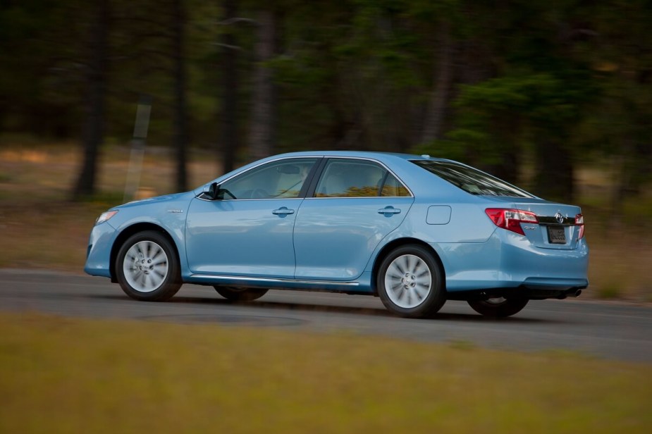 A used 2012 Toyota Camry Hybrid shows off its blue paintwork and rear-end styling. 