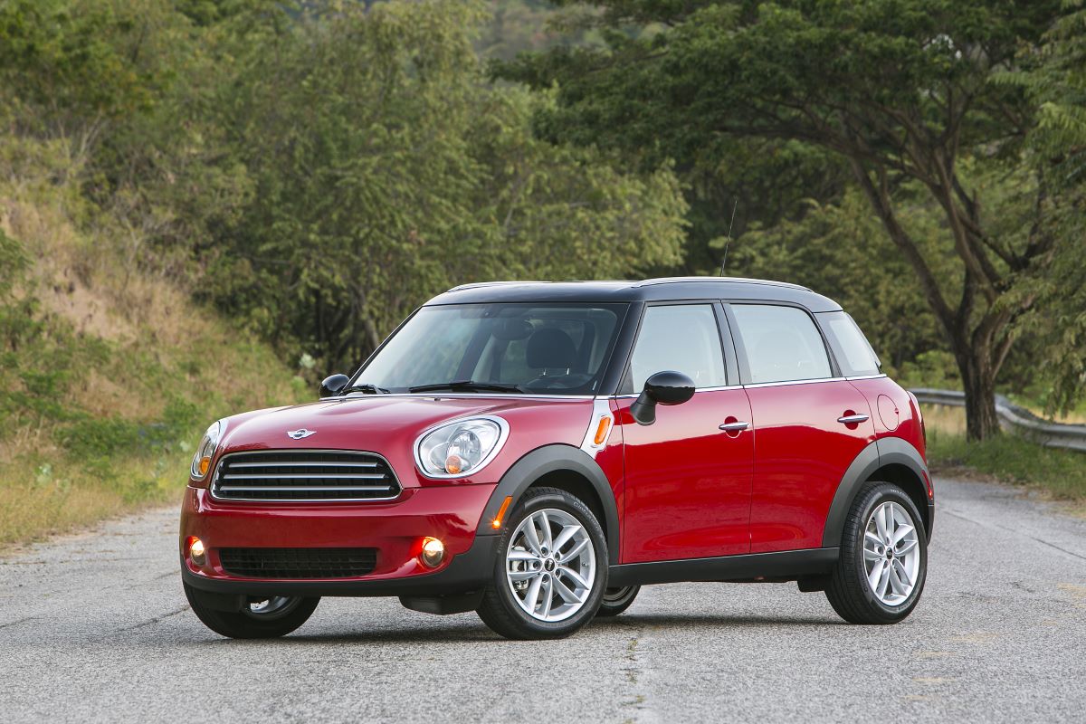 A red 2013 Mini Cooper Countryman subcompact luxury crossover SUV model parked on an asphalt road