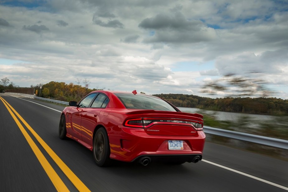A 2015 Dodge Charger Hellcat shows off its rear-end styling as it drives down a country road.