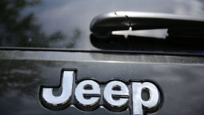 A 2014 Jeep Grand Cherokee model's badge on a car lot.