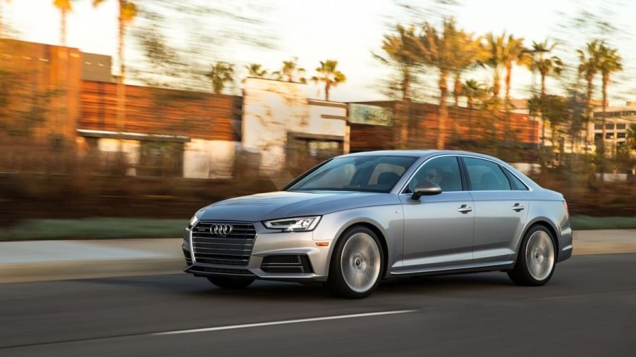 A used silver 2017 Audi A4 shows off its problem-free sports sedan styling on a coastal road.
