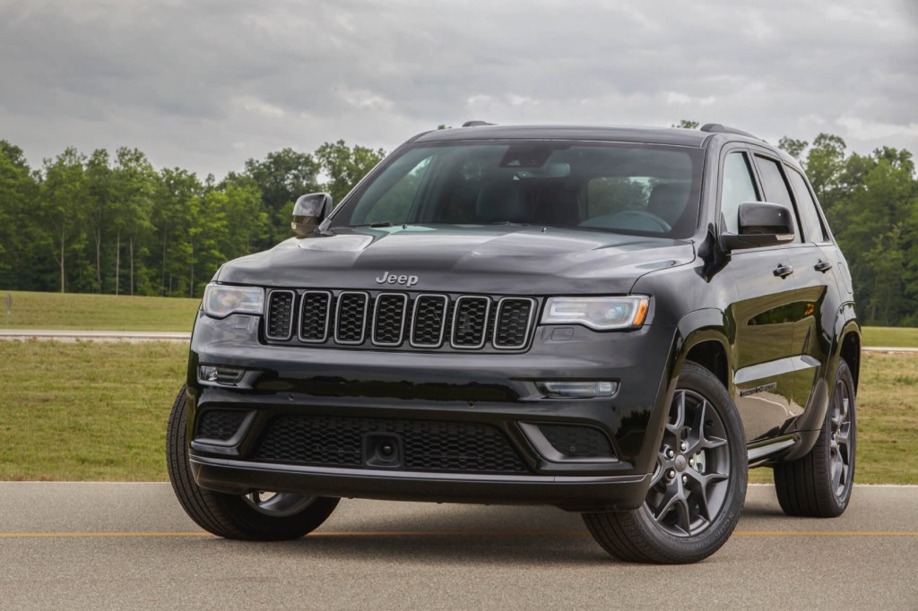 A black 2020 Grand Cherokee sits on pavement with gray skies overhead.