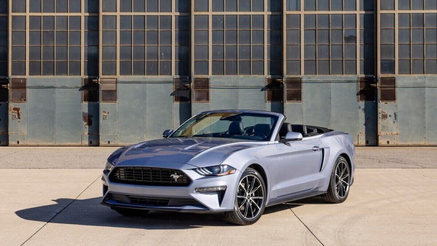 A silver 2023 Ford Mustang EcoBoost shows off its convertible car platform with the top down.