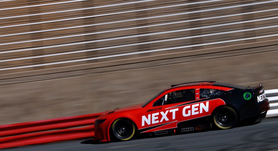 A Next Gen NASCAR Cup car race car completing test laps wearing unique red paint and driven by Dale Earnhardt Jr.