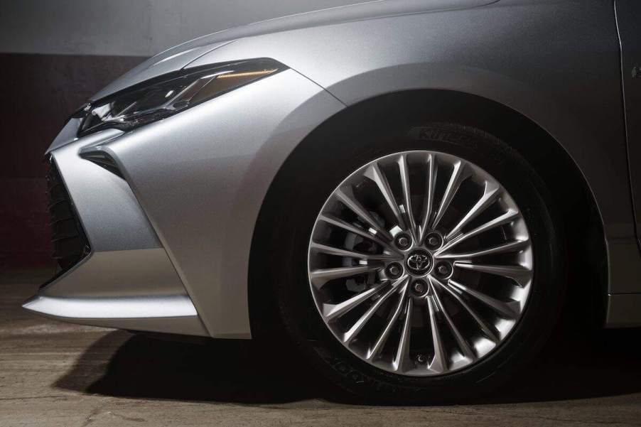 A silver Toyota Camry front headlight and tire.