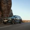 A new 2023 BMW XM drives along a desert mountain road.