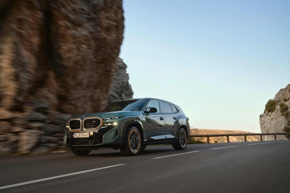 A new 2023 BMW XM drives on a desert mountain road. 