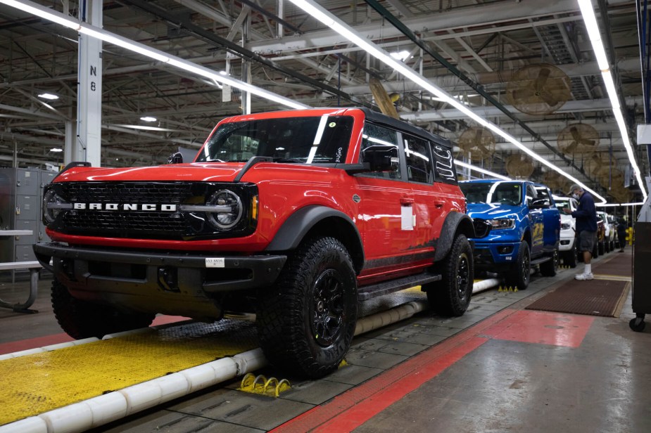 A red Ford Bronco on the production floor of a factory. 