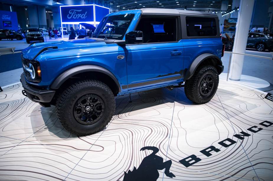 A blue two-door Ford Bronco on display at an auto show.