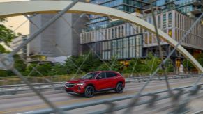 A red 2023 Buick Envision Essence drives on a bridge