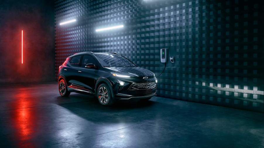 A dark color 2023 Chevrolet Bolt, which is one of the best Chevrolet SUVs, in a dark room lit with long bulbs.