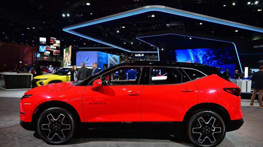 2023 Red Chevrolet Blazer at an auto show from the side.