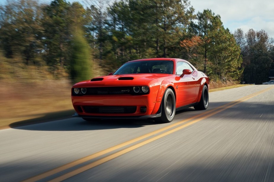 An old-school 2023 Dodge Challenger SRT Hellcat screams down a country road. 