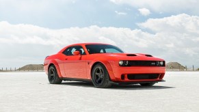 An orange 2023 Dodge Challenger SRT Hellcat shows off its muscle car proportions and fascia in the desert.