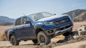 A blue 2023 Ford Ranger driving off-road. The 2023 Ford Ranger interior leaves a lot to be desired.