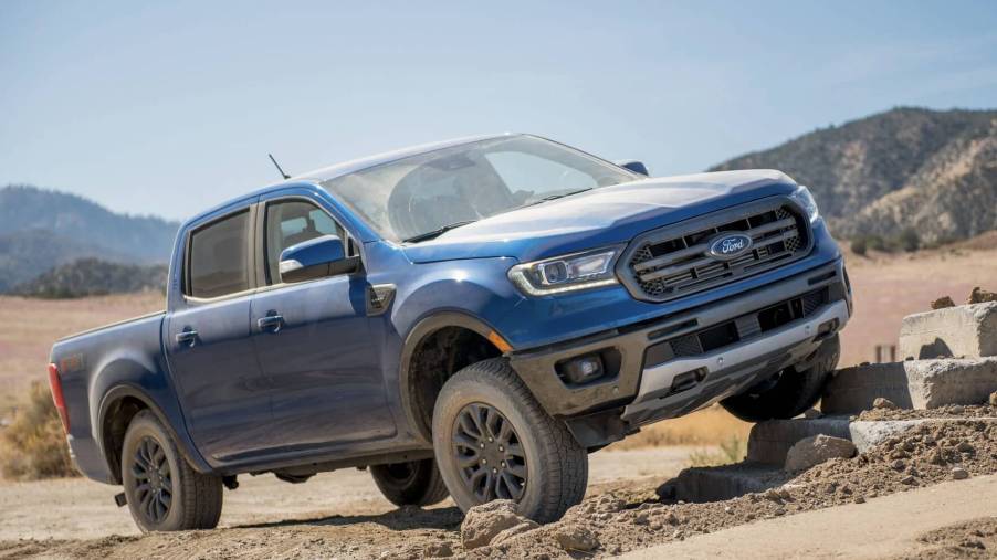 A blue 2023 Ford Ranger driving off-road. The 2023 Ford Ranger interior leaves a lot to be desired.