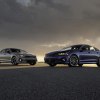 A pair of 2023 Kia K5 GT-Line models pose under an overcast sky.