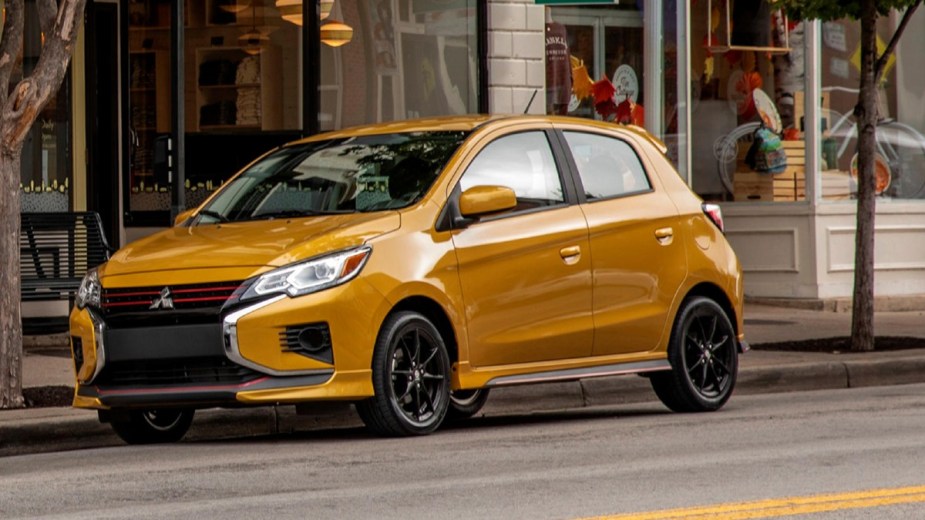 Yellow 2023 Mitsubishi Mirage parked in front of a business
