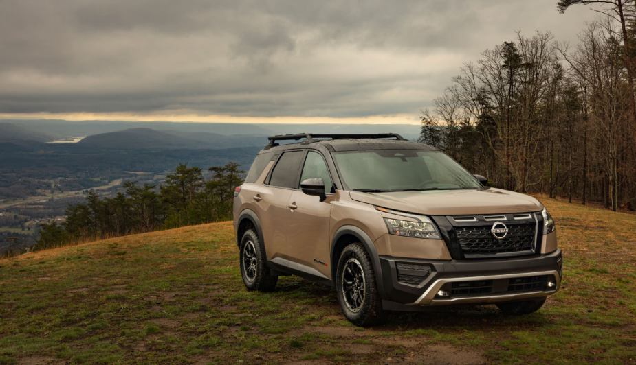 A 2023 Nissan Pathfinder, an alternative option to the Toyota 4Runner, sits atop a hill overlooking gray skies and countryside.