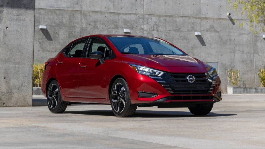 Red 2023 Nissan Versa Posed in front of a concrete building