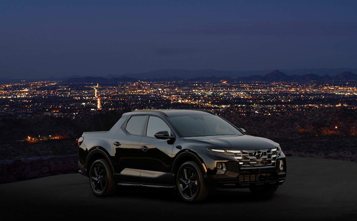 2023 trucks: A 2023 Santa Cruz Night parked in front of a night sky with a city scene