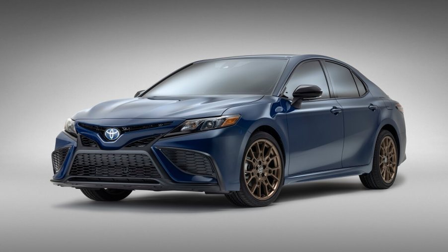A blue 2023 Toyota Camry Hybrid shows off its bronze wheels.