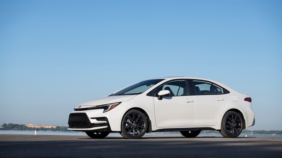 A white 2023 Toyota Corolla Hybrid car shows off its side profile.
