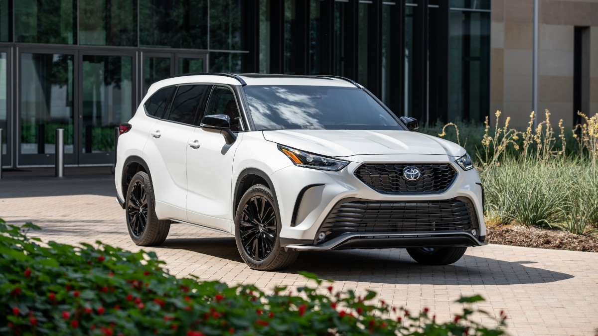 White 2023 Toyota Highlander posed with flowers in the foreground
