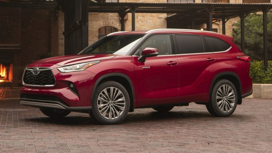 Red 2023 Toyota Highlander Hybrid posed and parked